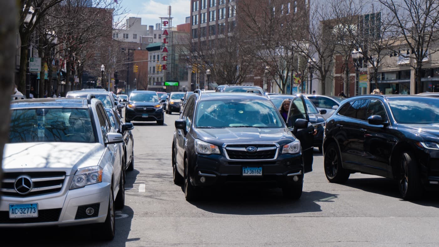 Double-parked SUV beside curbside vehicles in Stamford, Connecticut